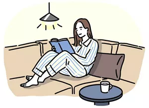 ソファに座りながら読書を楽しむ女性のイラストイメージ